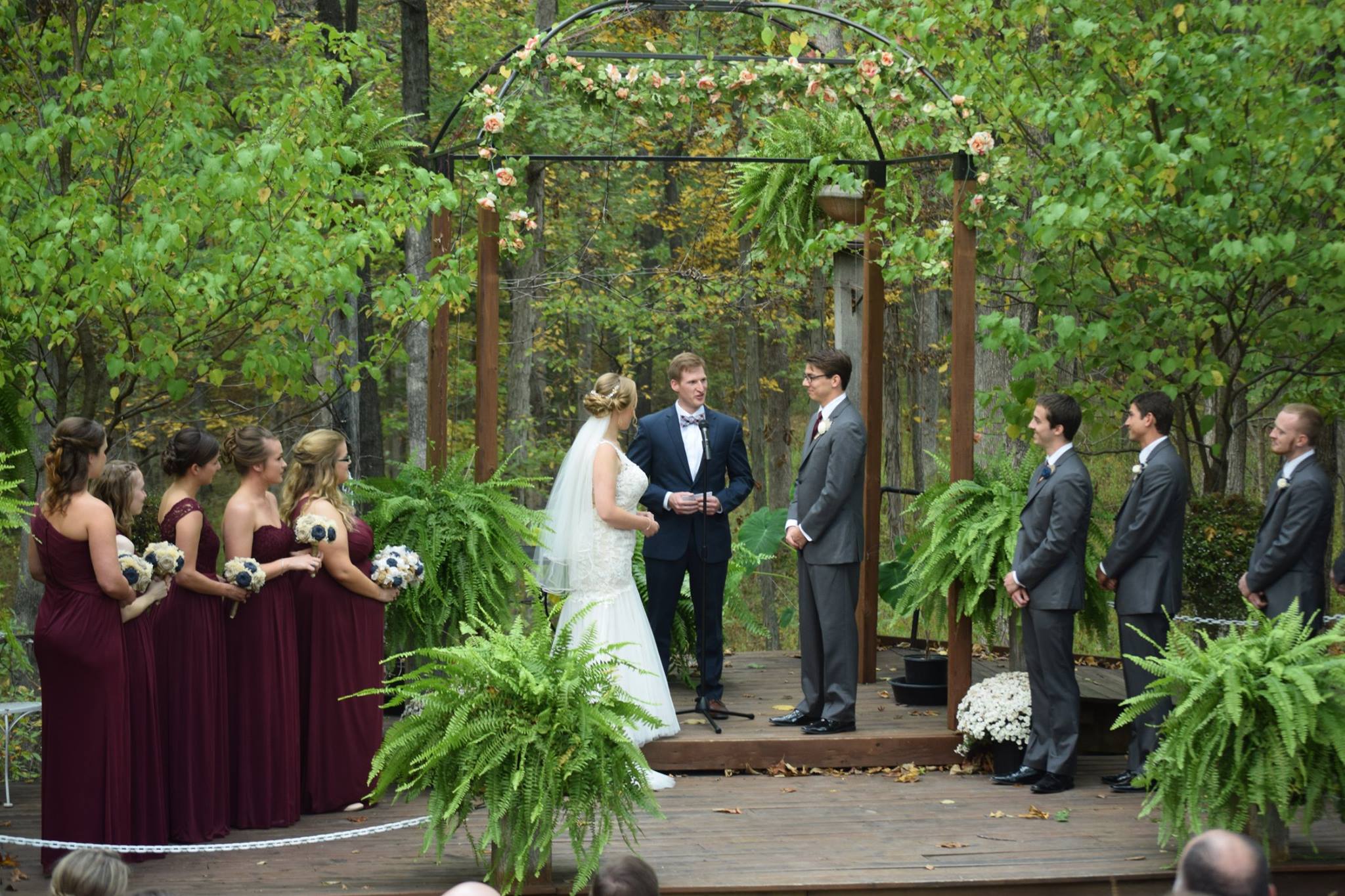 bride and groom saying vows under pergola during outdoor fall wedding
