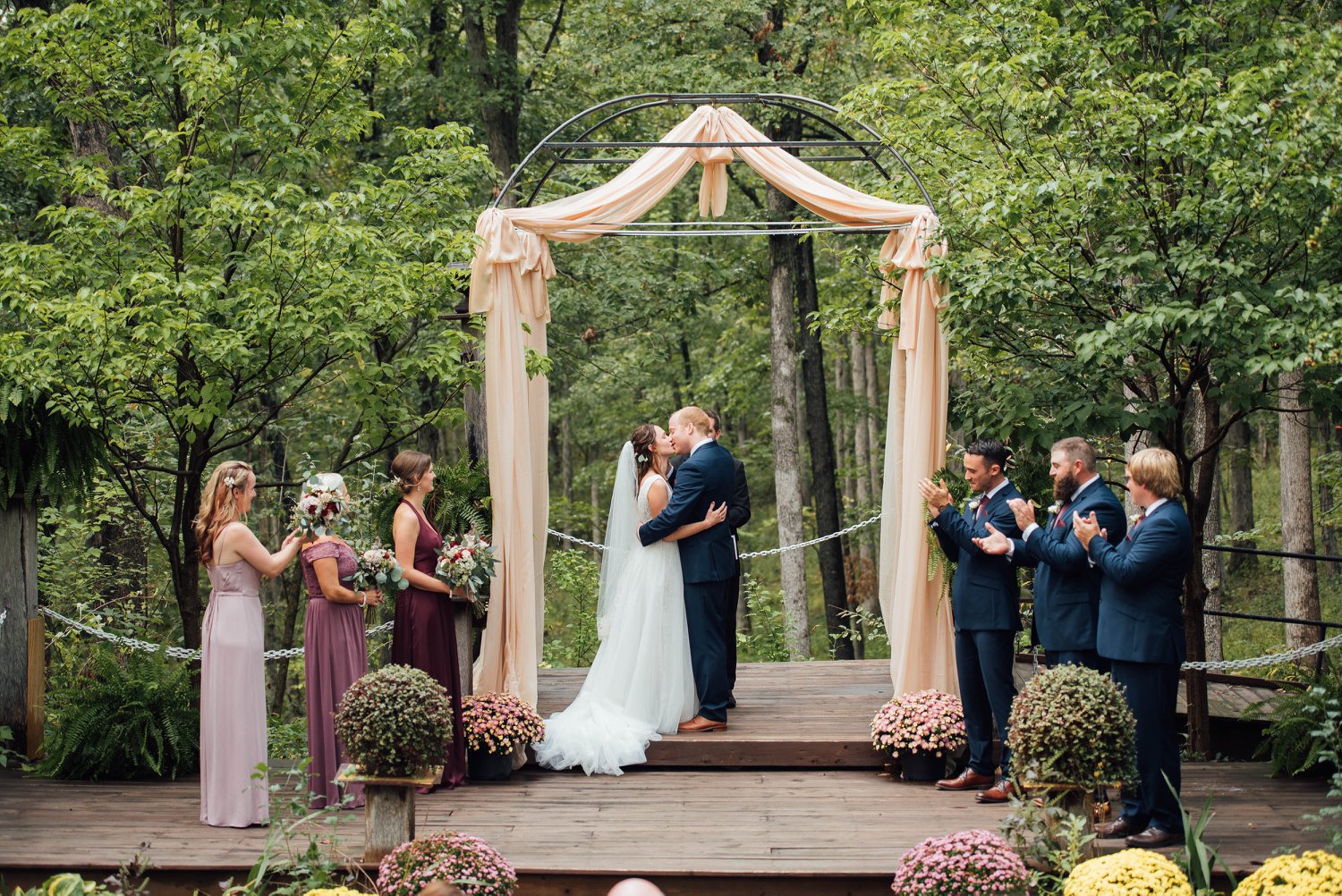 bride and groom's first kiss in outdoor wedding ceremony